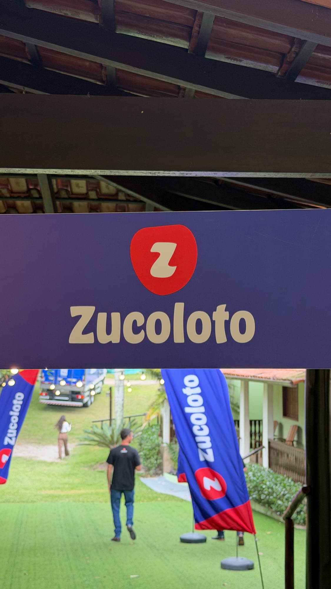 Recepção do evento montada no gramado, com arco inflável na entrada e a casa ao fundo